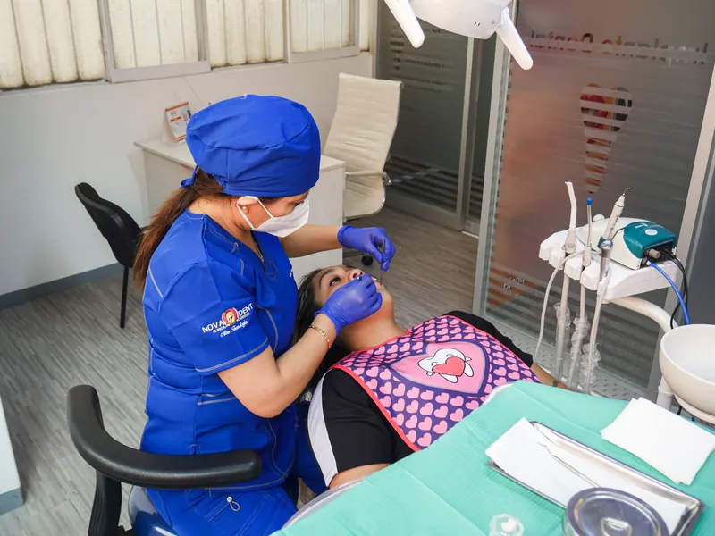Odontóloga atendiendo a una paciente en el consultorio de Novaodent