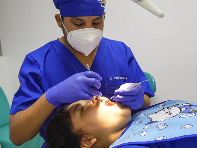 Especialista atendiendo a una paciente en el sillón dental
