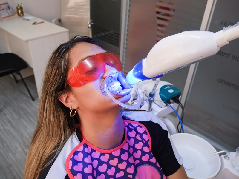 Paciente recibiendo un tratamiento estético dental con luz especializada